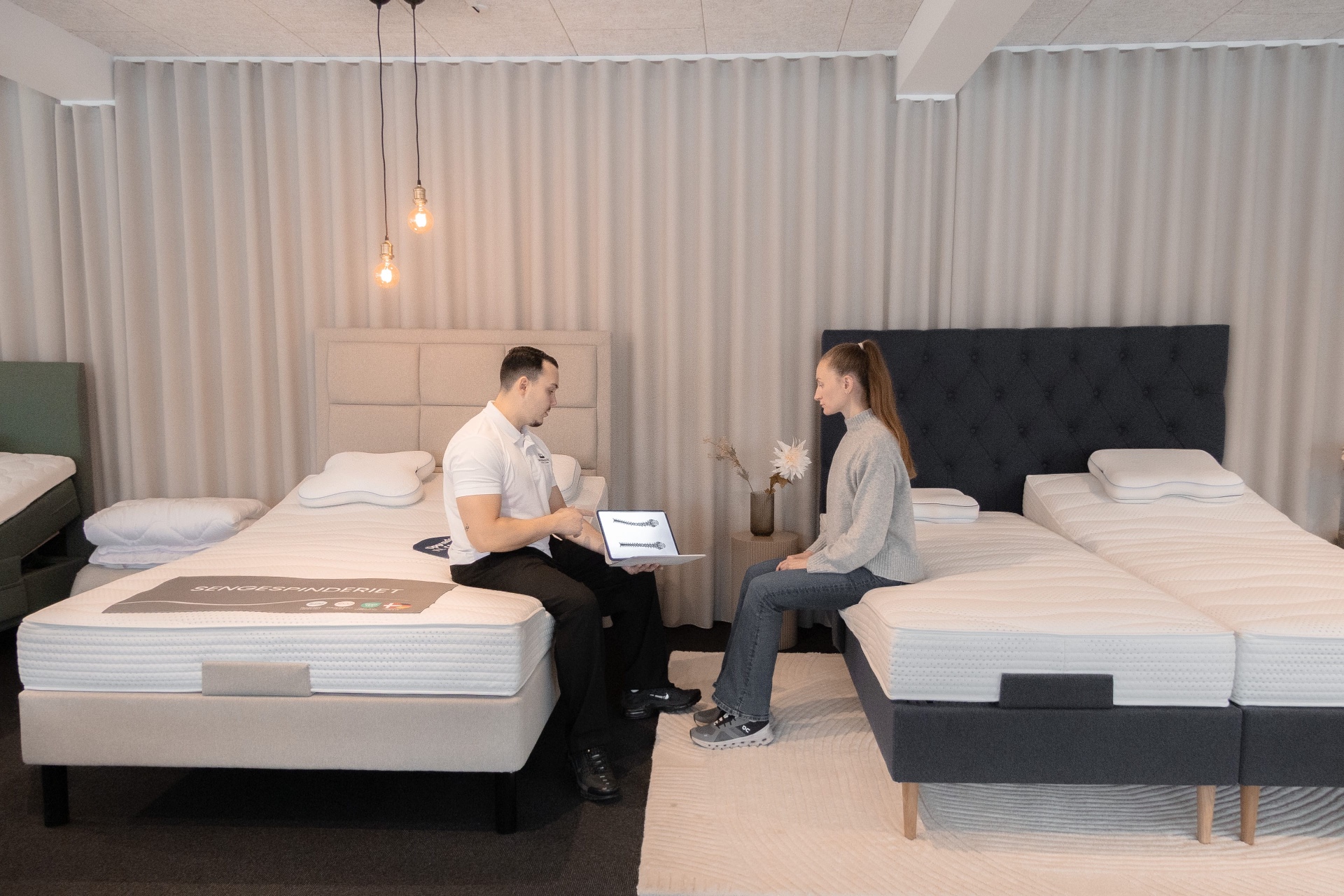 Søvnspecialist gennemgår 3D-rygmåling med kunde i showroom
